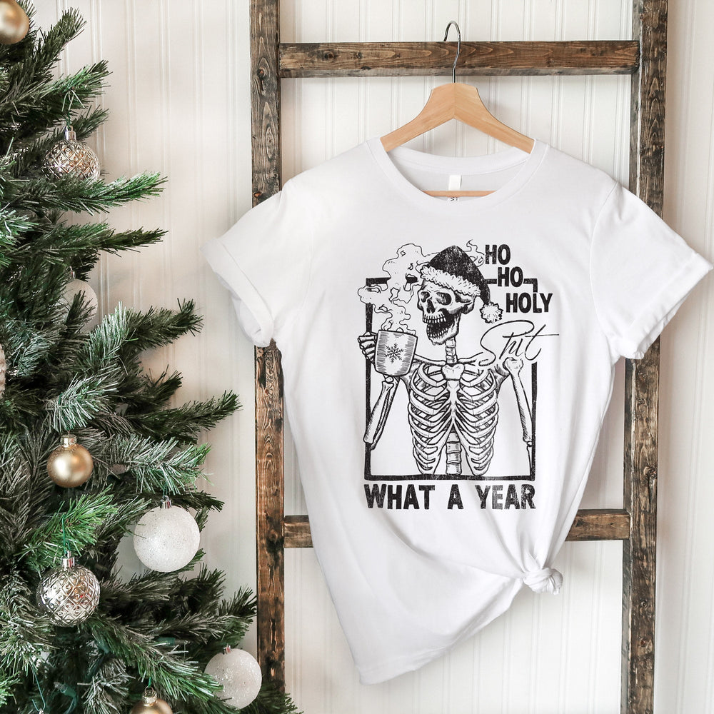 a funny christmas skeleton shirt hanging next to a christmas tree