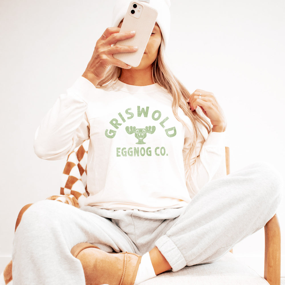A young woman wearing a Griswold eggnog Co. long sleeve tee in Ivory