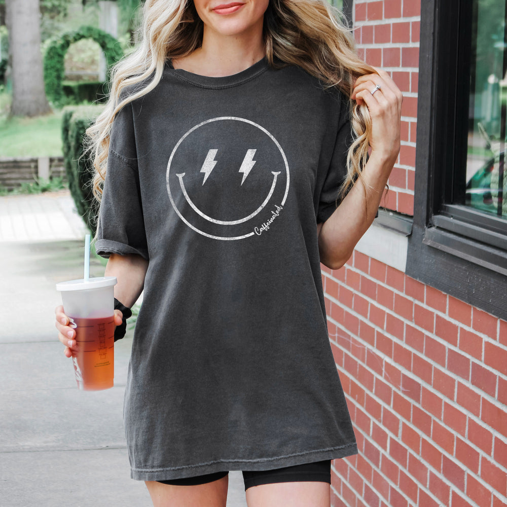 
                  
                    a pretty woman holding a beverage, wearing a retro caffeinated tee in pepper
                  
                