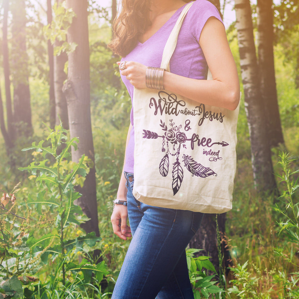 
                  
                    a woman outdoors carrying a bag printed with the free indeed svg in purple
                  
                