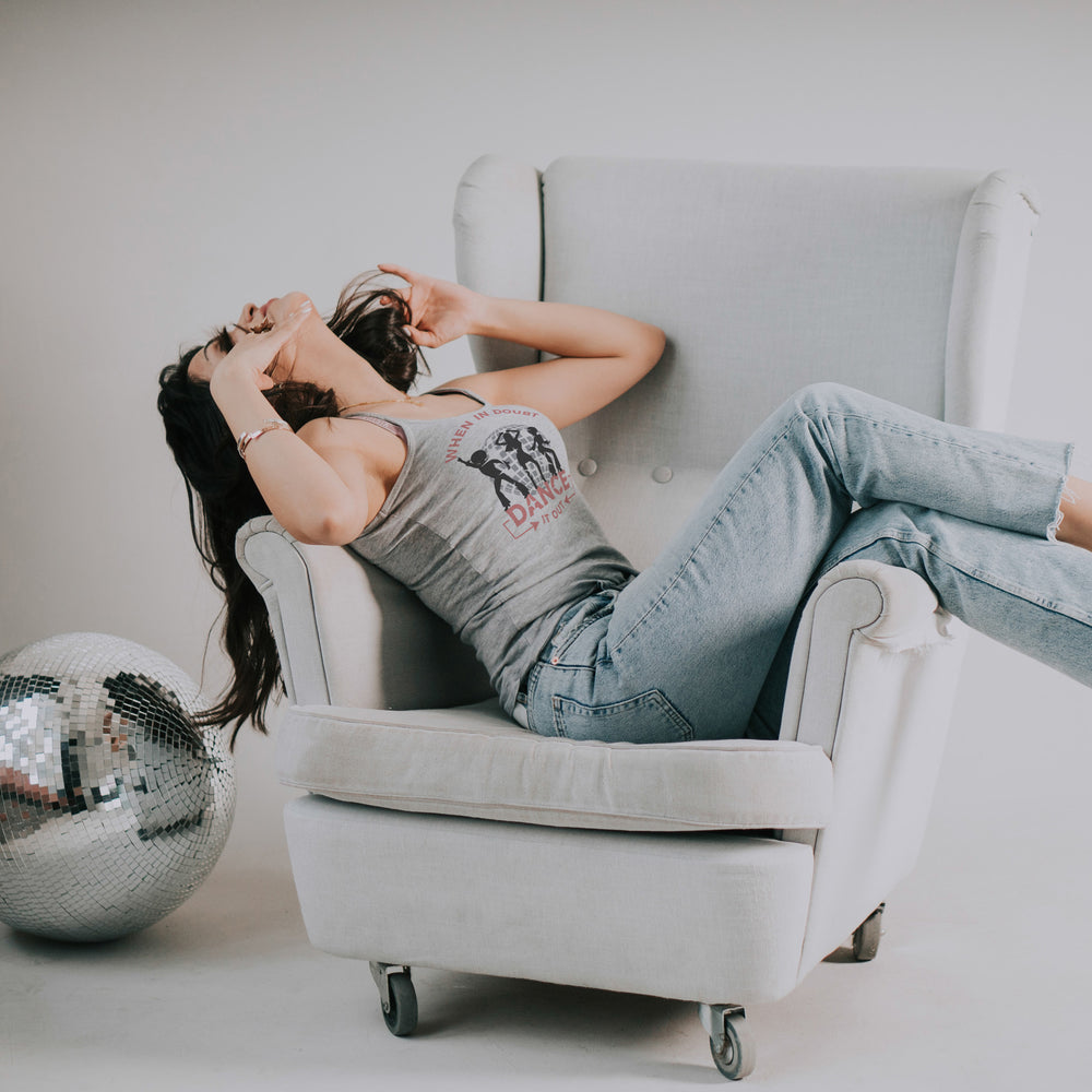 
                  
                    young woman enjoying music, laying across an armchair, wearing a tee with  when-in-doubt-dance-it-out-svg.
                  
                