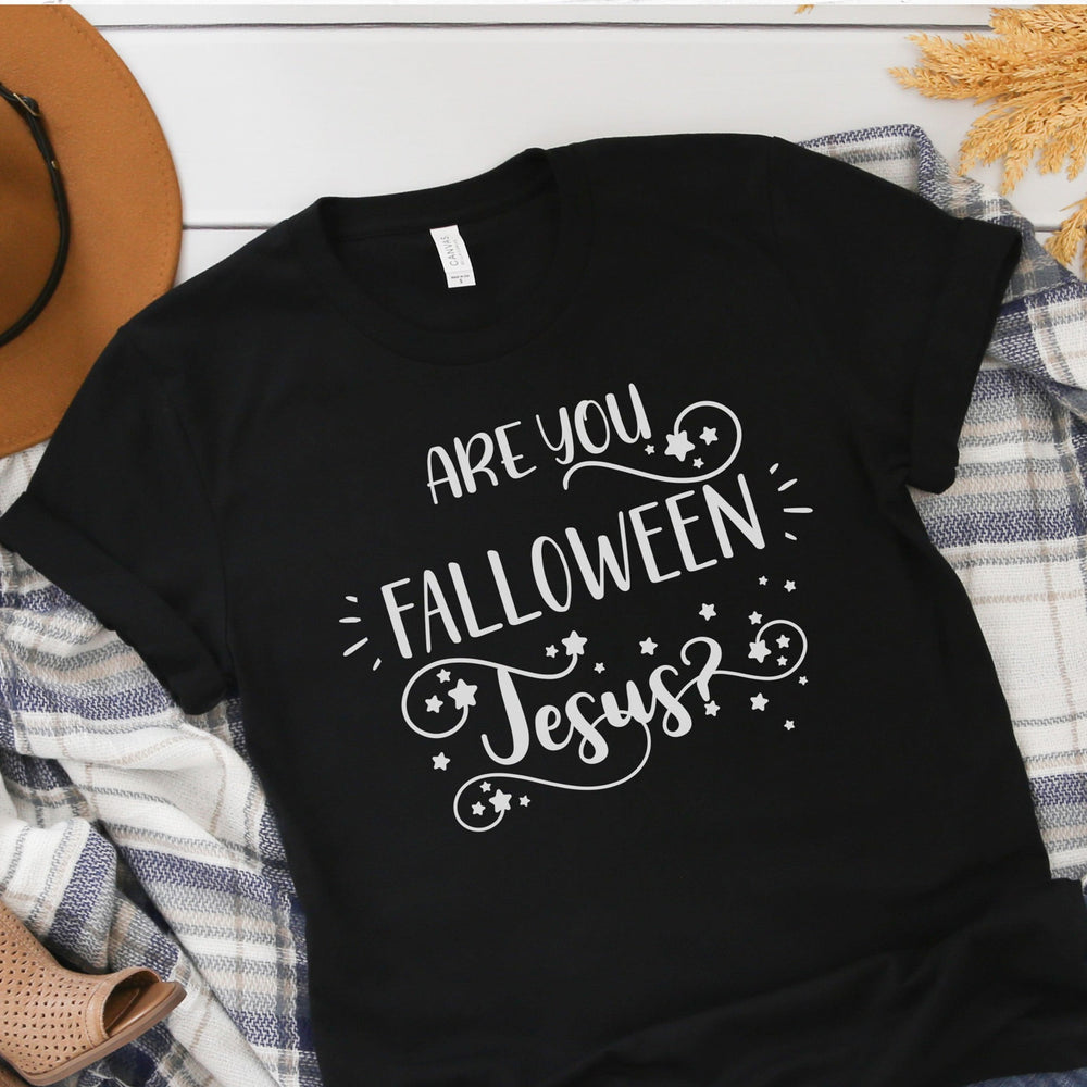 
                  
                    Are You FALLOWEEN Jesus svg printed on a black shirt layed out, surrounded by fall themed items
                  
                