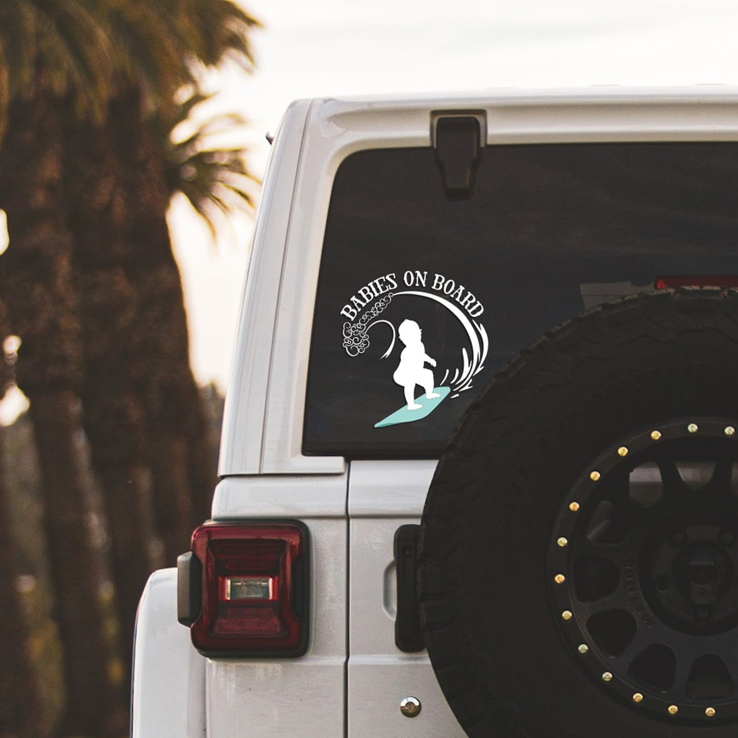 
                  
                    babies on board, surfboarding svg, cut as a car decal, shown on the rear window of a black jeep
                  
                