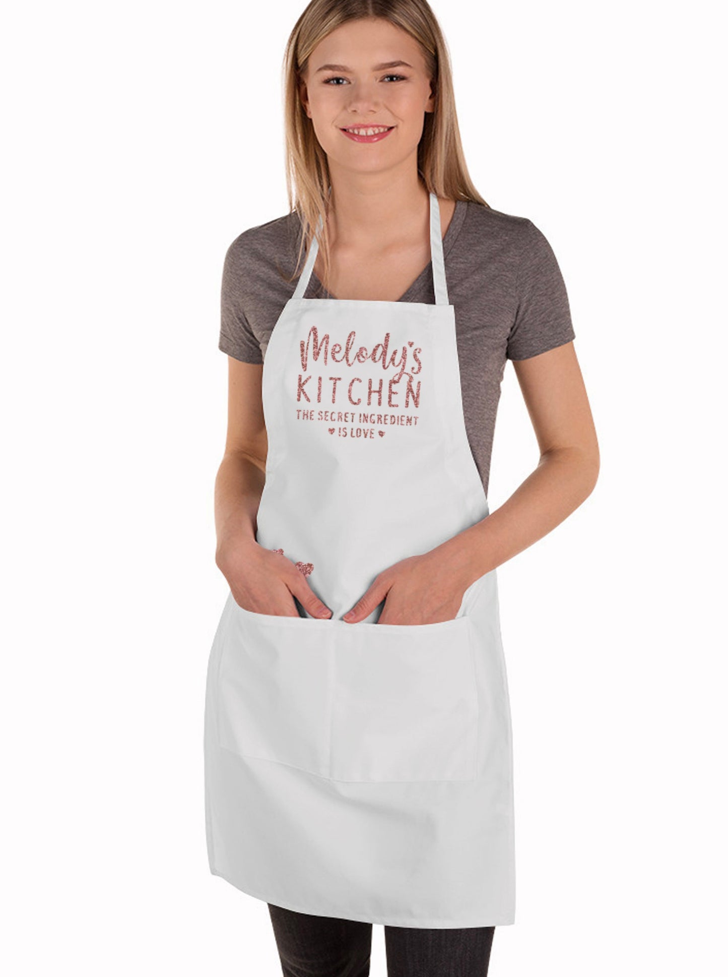 a young woman wearing a personalized secret ingredient is love apron apron in white