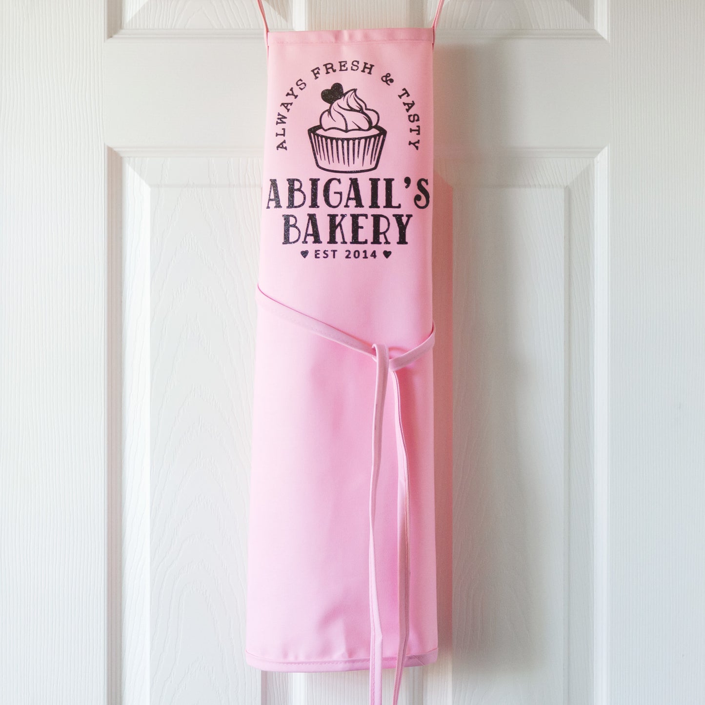 a kid's personalized cupcake baking apron in pink pastel
