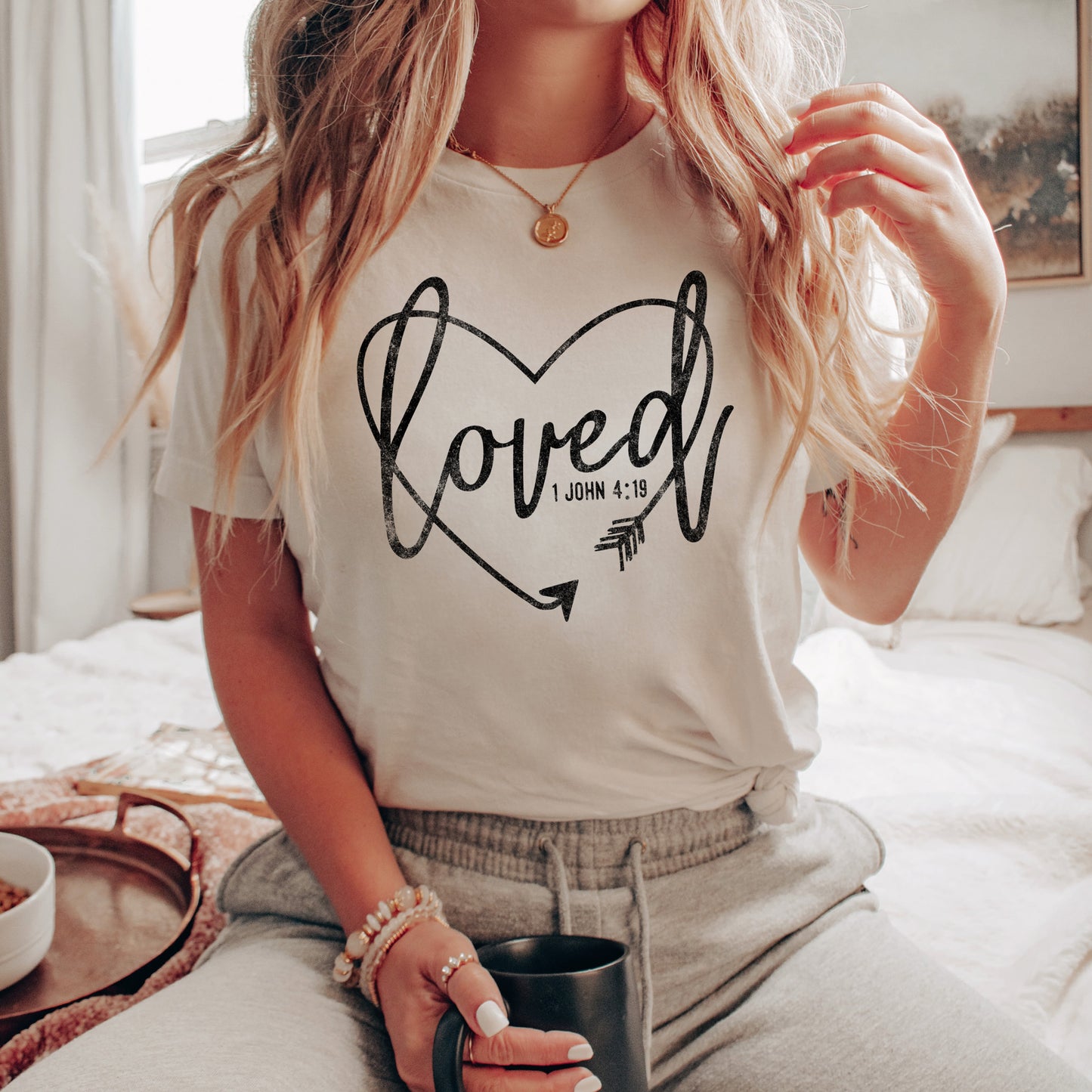 a young woman wearing a loved christian tee in white 