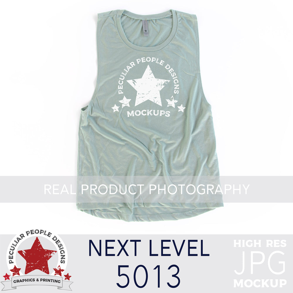 a Stonewash Green, next level 5013 muscle tank flat lay mockup with a white background by peculiar people designs