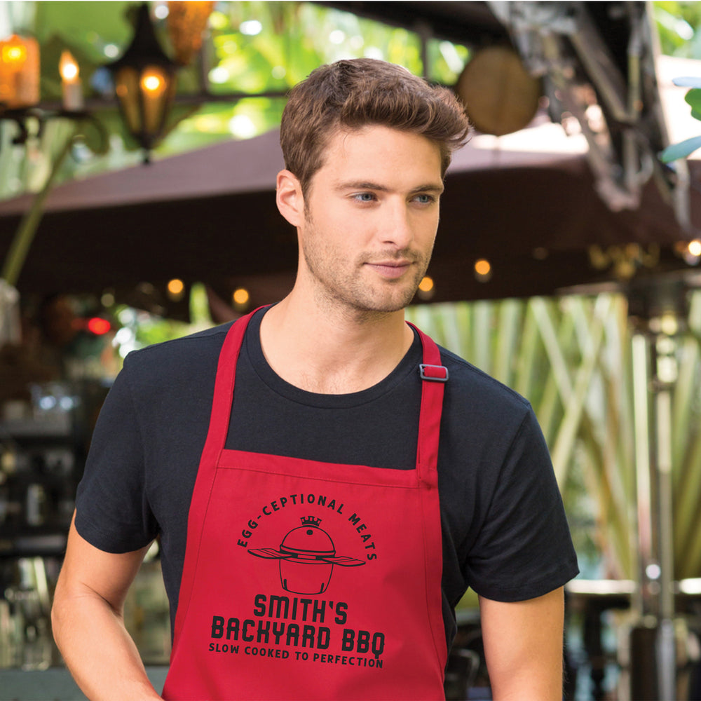 a young man wearing a personalized kamado grilling apron in red