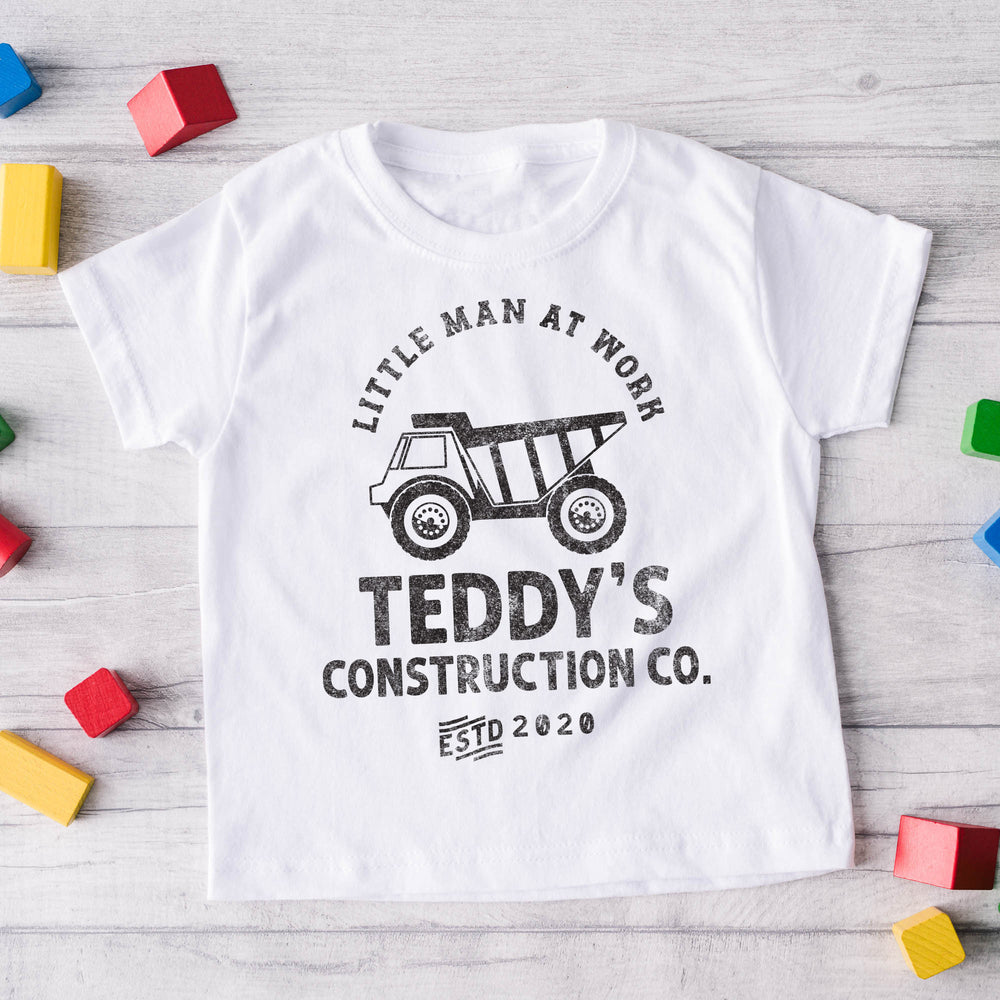 
                  
                    a kid's dump truck construction co. shirt in white surrounded by building blocks
                  
                