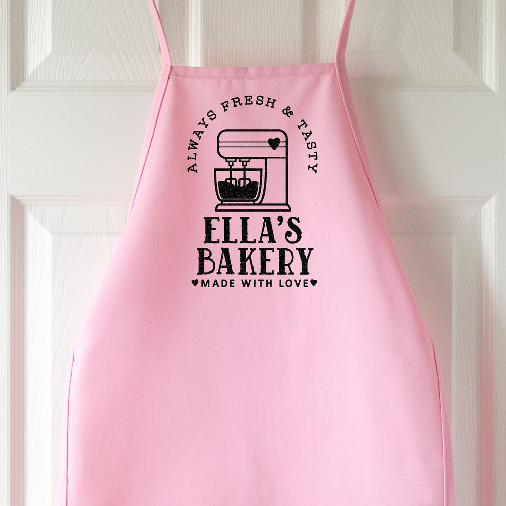 a kids personalized baking apron in pink pastel