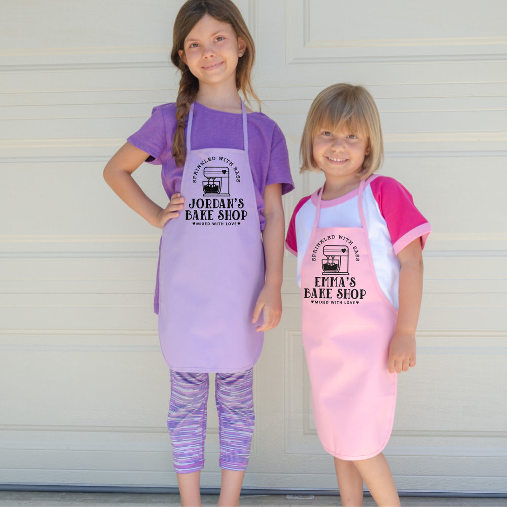 
                  
                    two young girls wearing personalized kitchen mixer baking aprons
                  
                
