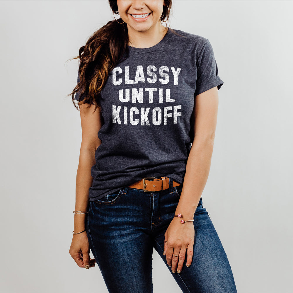 
                  
                    a young smiling woman wearing a classy until kickoff shirt in navy
                  
                