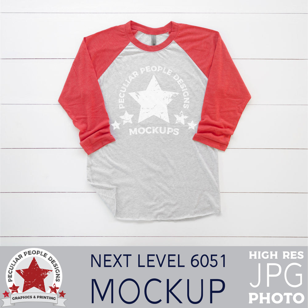 mock up photo of a red raglan, layed out in a masculine way, on a wood background
