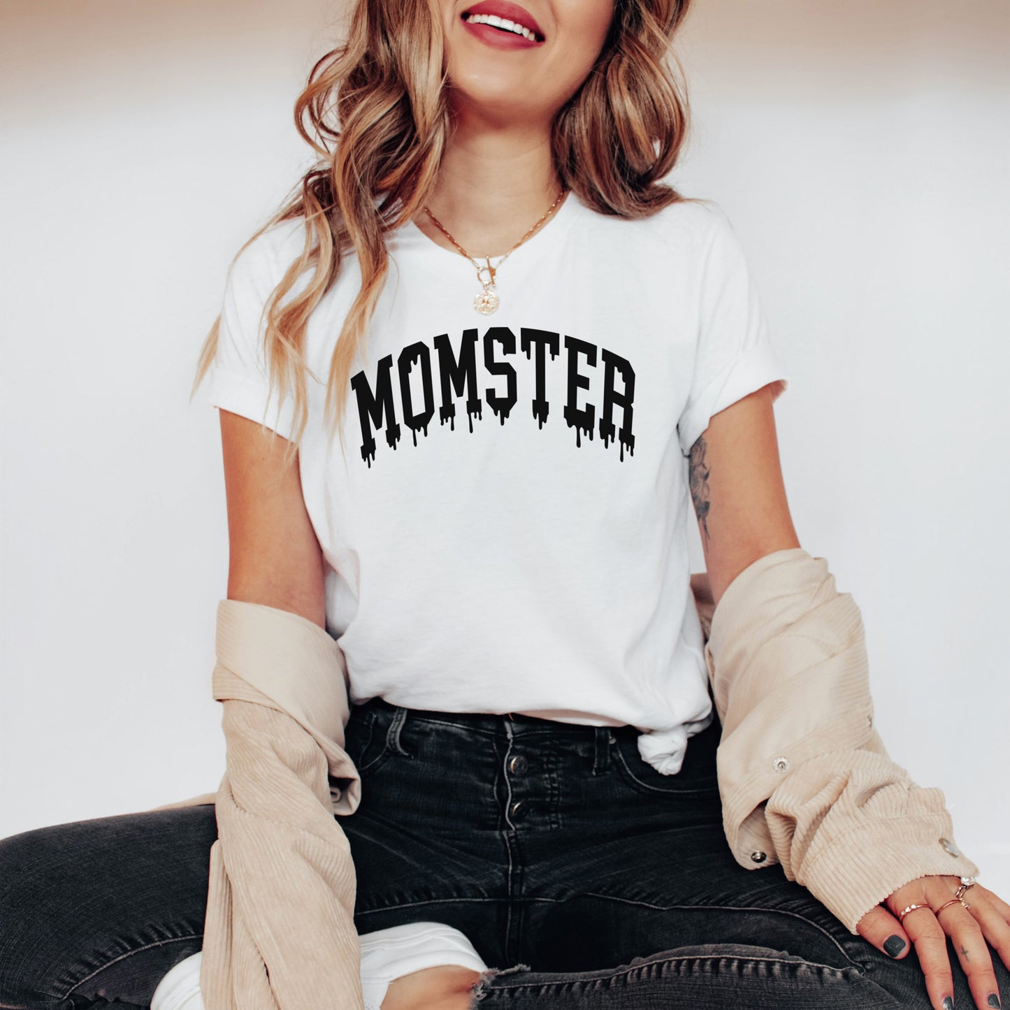 
                  
                    a young woman wearing a white momster halloween shirt
                  
                