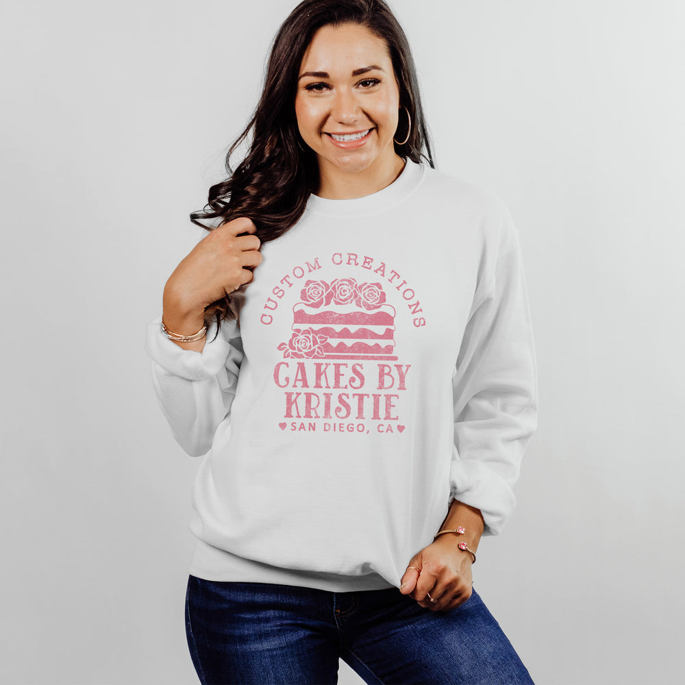
                  
                    a pretty young woman wearing a personalized cake baker sweatshirt in white
                  
                
