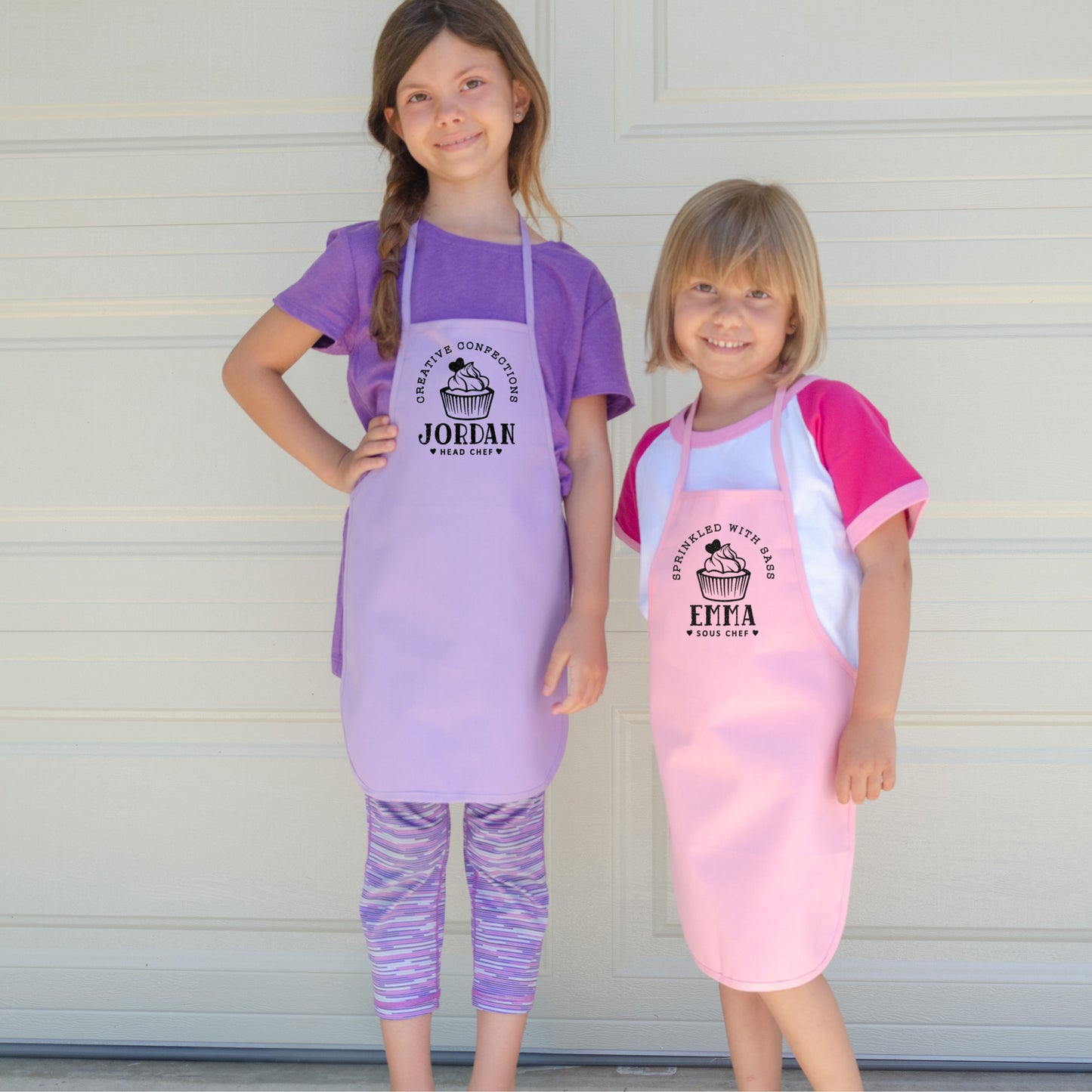 two young girls wearing toddler personalized cupcake baking aprons