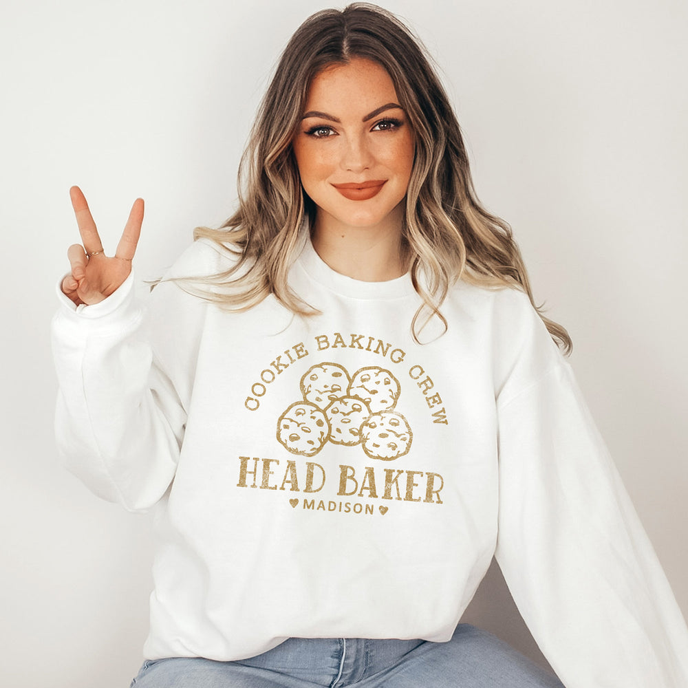 a pretty young woman making the peace sign, wearing a personalized cookie baker sweatshirt in white