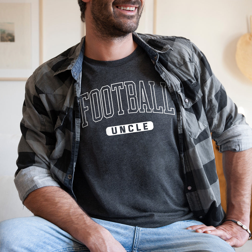 
                  
                    a young man wearing a football uncle shirt in grey
                  
                