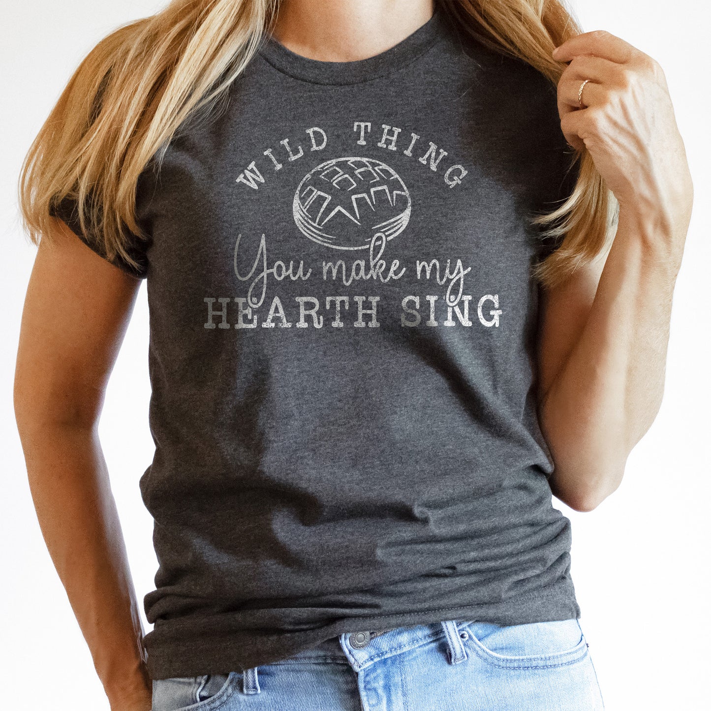 
                  
                    a young woman wearing a dark grey sourdough shirt that says wild thing, you make my hearth sing
                  
                