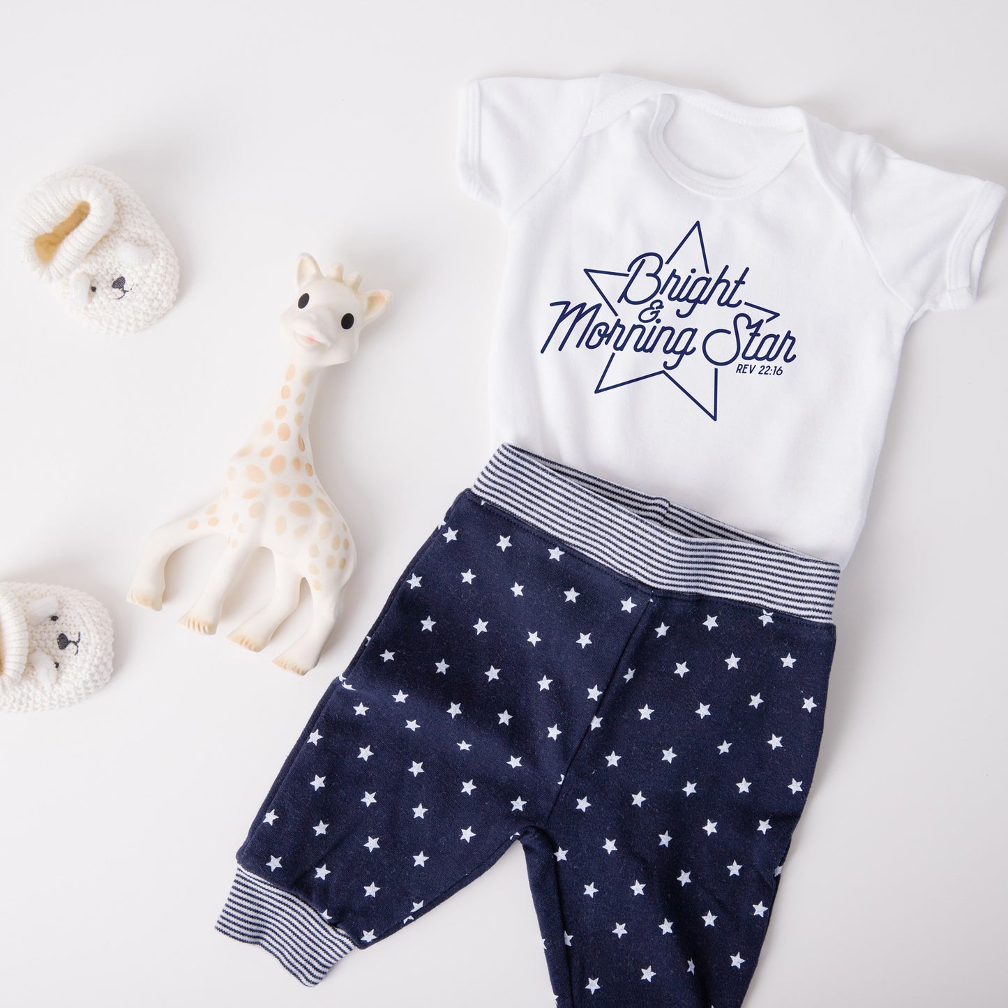 
                  
                    bright-morning-star-svg on a baby onesie. layed out with blue pants with stars
                  
                
