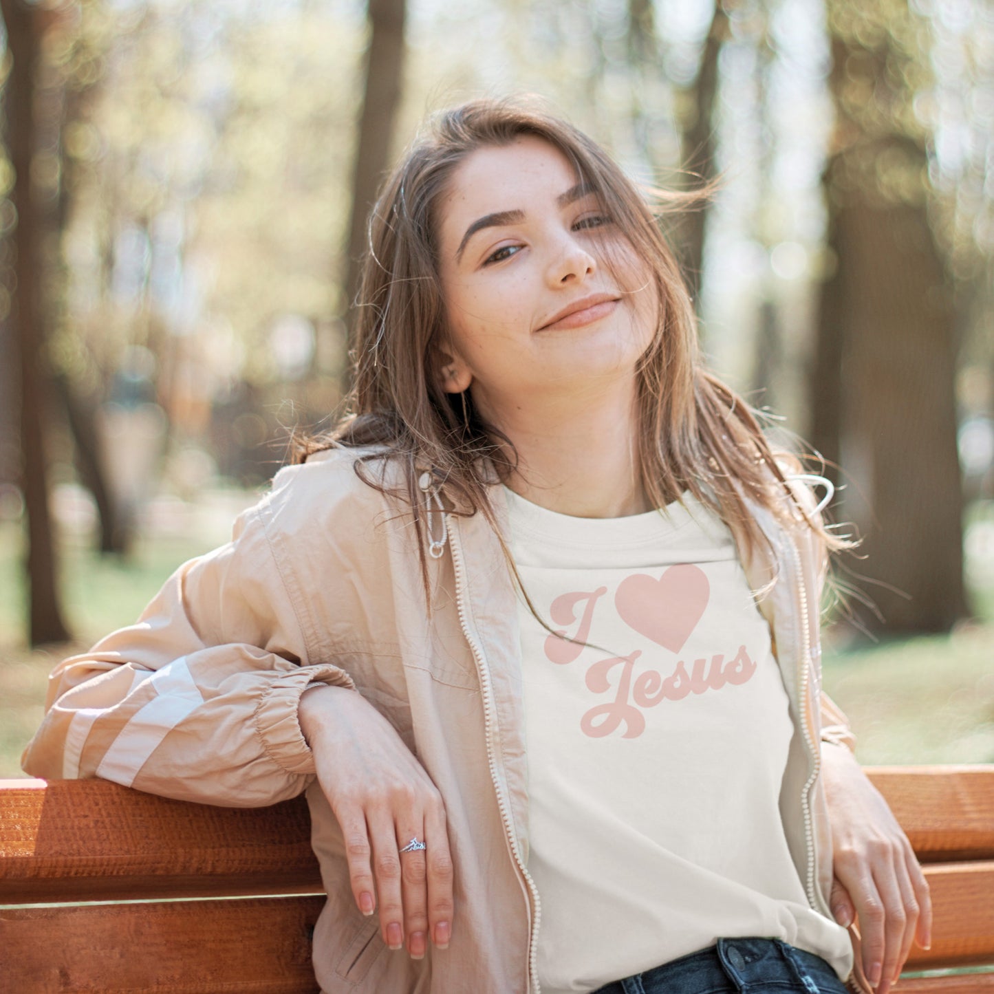 
                  
                    a young girl relaxed on a park bench wearing anI Heart Jesus svg tee
                  
                